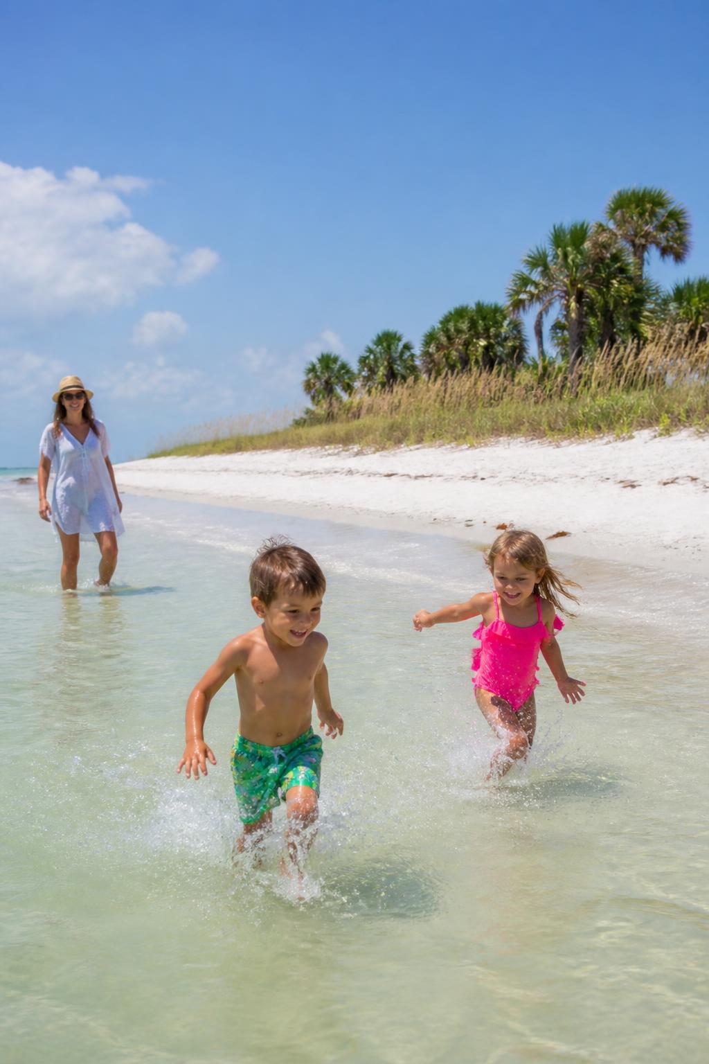 Kids running through the shallow gulf water at a Sarasota County beach